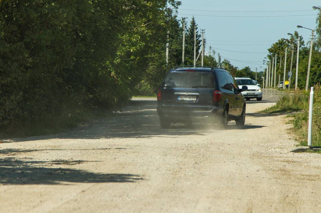 Kenčia: pravažiuojantys automobiliai nuolat kelia dulkių debesis.