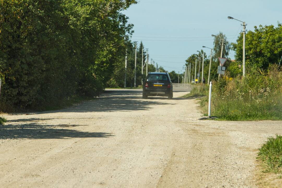 Kenčia: pravažiuojantys automobiliai nuolat kelia dulkių debesis.