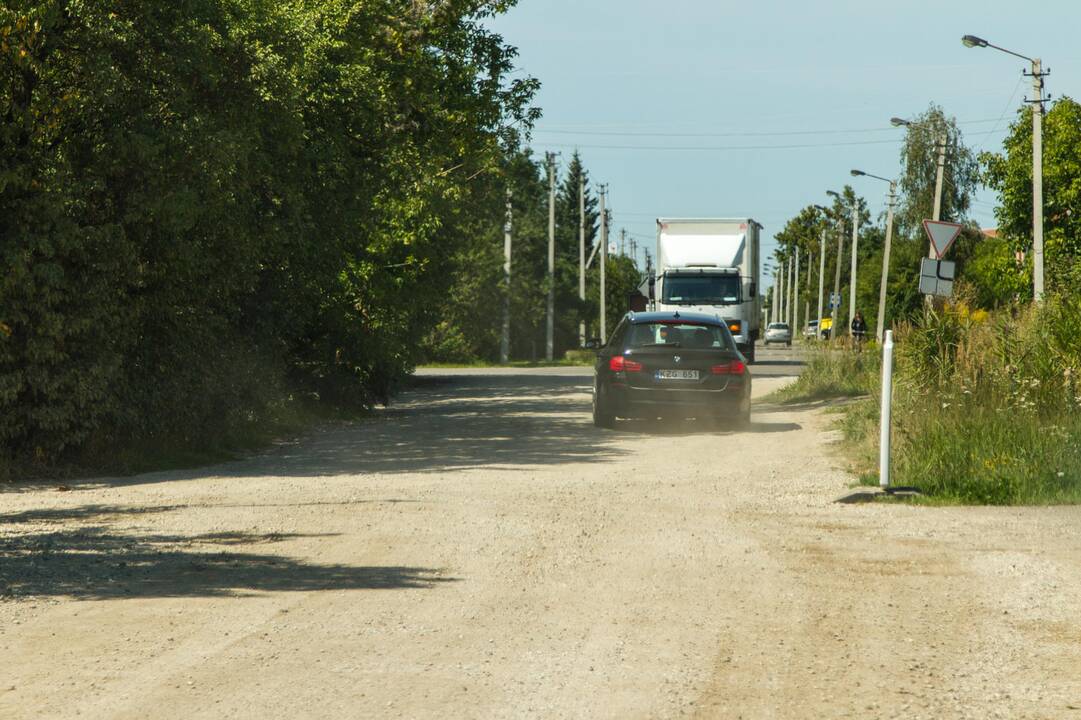 Kenčia: pravažiuojantys automobiliai nuolat kelia dulkių debesis.