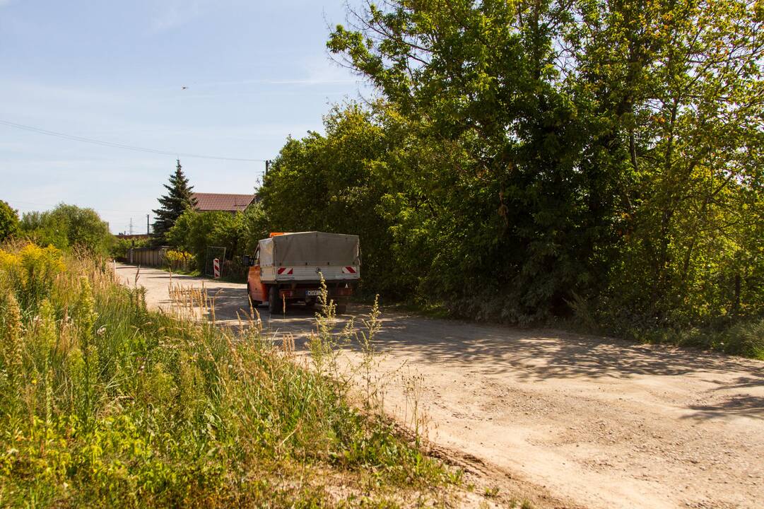 Kenčia: pravažiuojantys automobiliai nuolat kelia dulkių debesis.