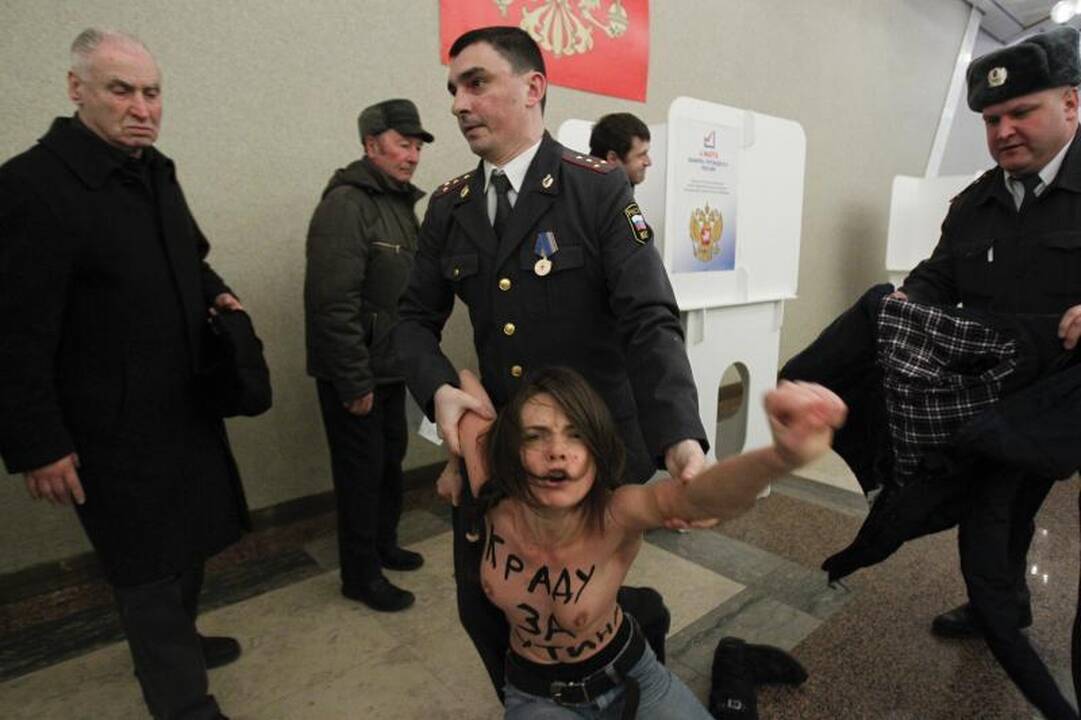 Vladimiro Putino rinkimų apylinkėje - šokiruojanti protesto akcija