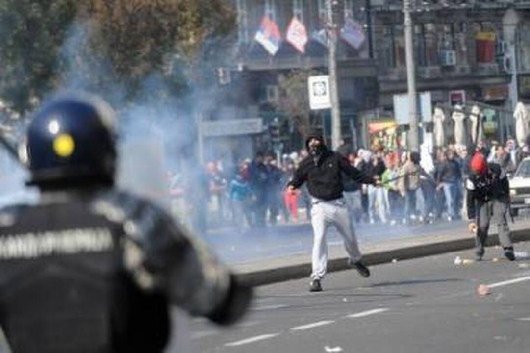 Įniršis: riaušininkai svaidė akmenis į policininkus ir sukėlė gaisrą prie valdančiosios partijos būstinės.