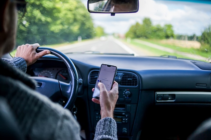 Sąlygos: vairuojant galima naudotis telefonu, jei jis valdomas laisvų rankų įranga ir laikomas specialiame laikiklyje. 