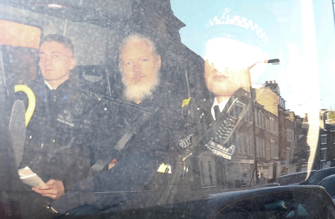 Julianas Assange'as (viduryje)