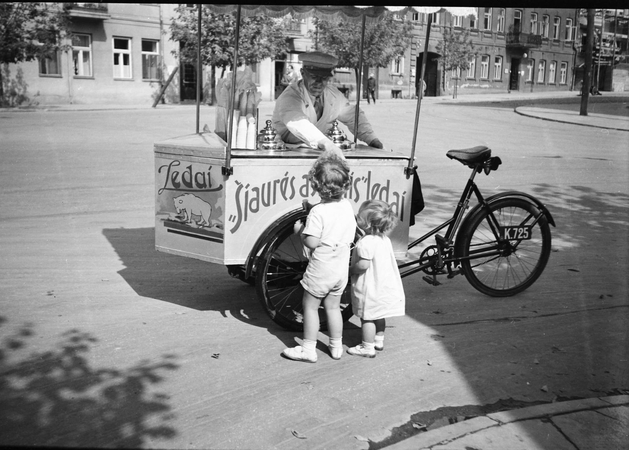 Skanu: ledų pardavėjas ir nuolatiniai jo klientai. Kaunas, 1938 m.