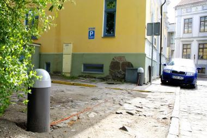 Naujovė: senamiestyje įsikūrę kultūros paveldo sergėtojai savo kiemą atsitverė stulpeliais, apjuostais grandine, kuri valdoma mobiliuoju telefonu.