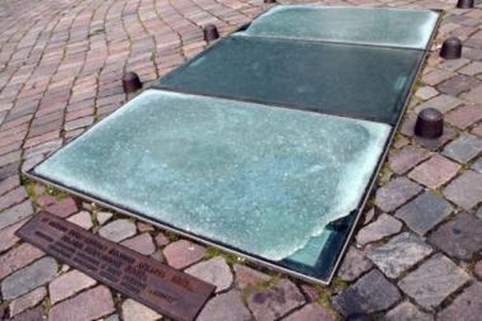Apmaudu: smalsūs miestiečiai ir turistai veltui stengiasi įžvelgti, ką slepia apgadintas stiklas Rotušės aikštės grindinyje.
